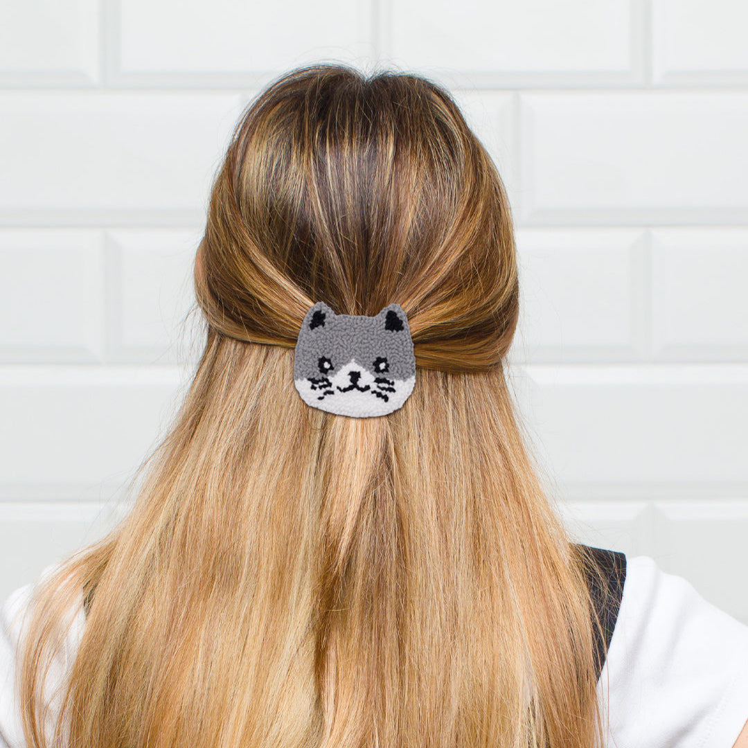 handmade grey cat punch needle hair clip worn in blonde hair