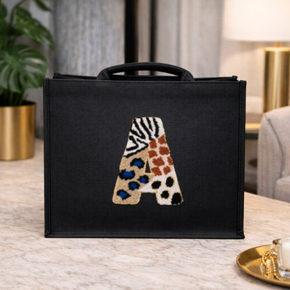 Jute alphabet shoulder bag with punch needle letter design on structured black base - A