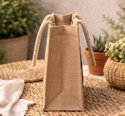 Jute bag with braided handles on woven surface