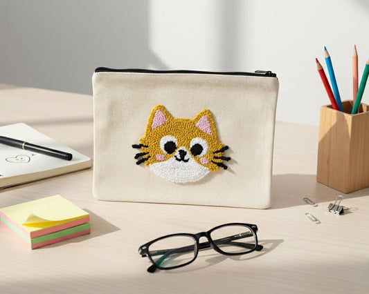 Pouch with a cat face design on a desk with stationery items