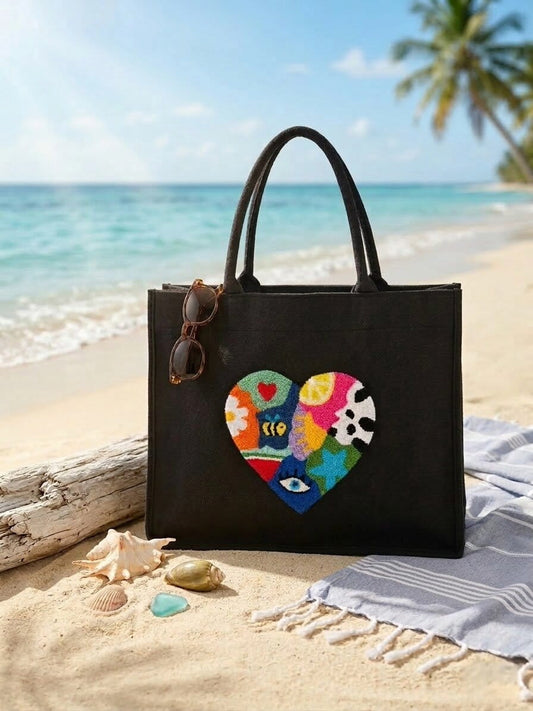 Handmade black jute punch needle floral heart shoulder bag on a beach