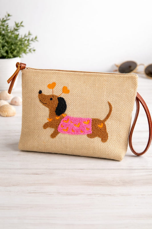 Beige pouch with embroidered dachshund design on a wooden surface