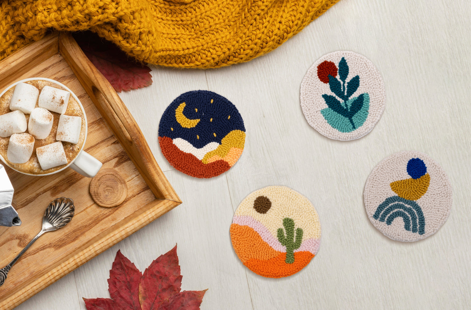 Set of handmade boho punch needle coasters on a table