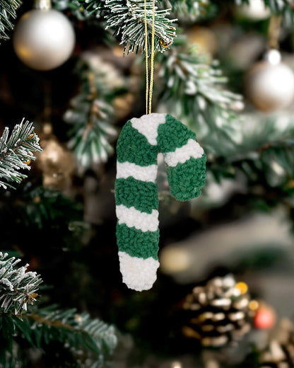 Punch needle candy cane ornament by Kozi Crafts styled on a decorated Christmas tree with festive lights. - green