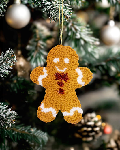 Handmade punch needle gingerbread ornament hanging on a Christmas tree - white
