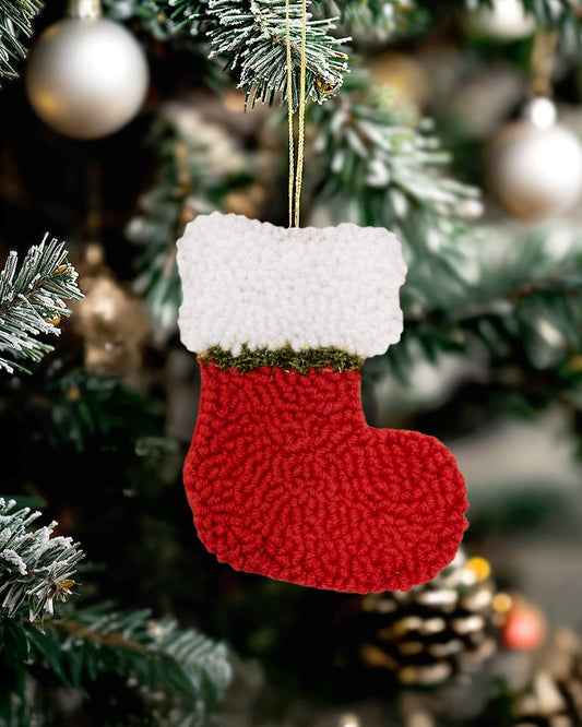 Handmade punch needle Christmas stocking ornament in red hanging on a decorated Christmas tree.