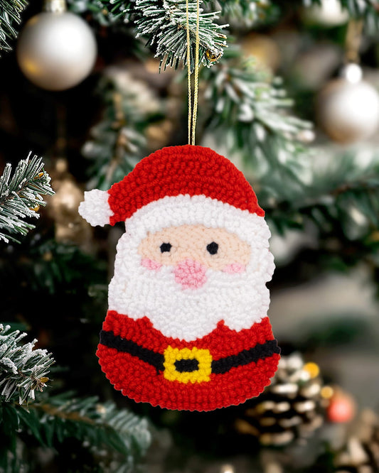 Handmade punch needle Santa ornament hanging on a decorated Christmas tree.