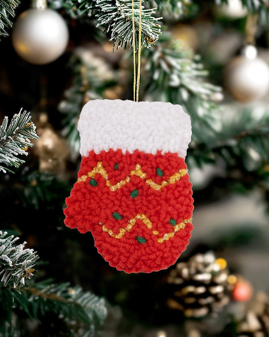 Handmade punch needle sparkle mitten ornament hanging on a decorated Christmas tree.